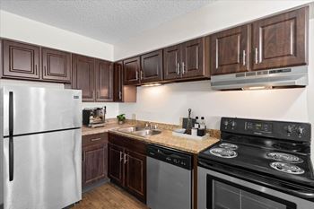 A kitchen with a stove, refrigerator, and microwave.